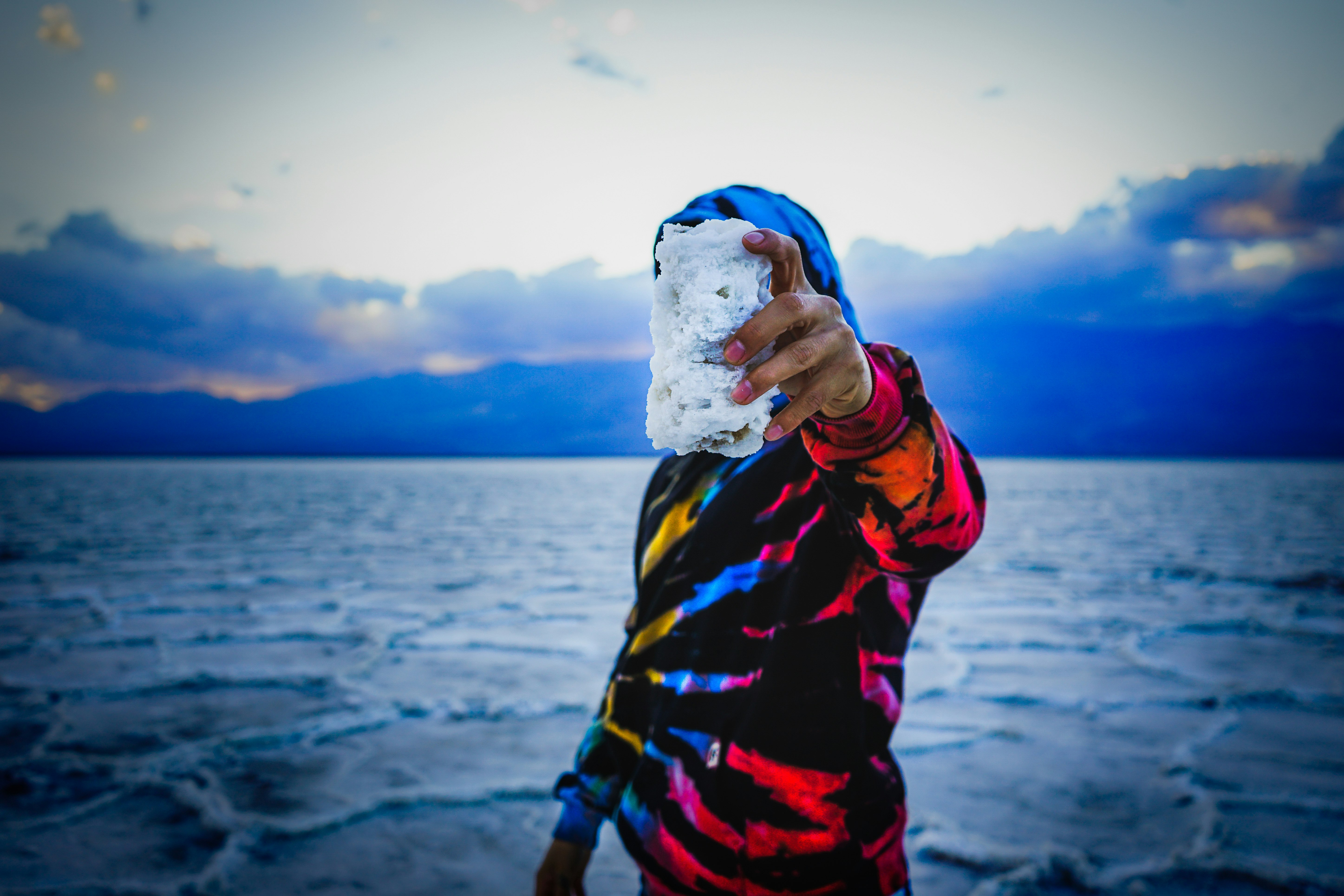 person in red blue and yellow jacket holding ice cream