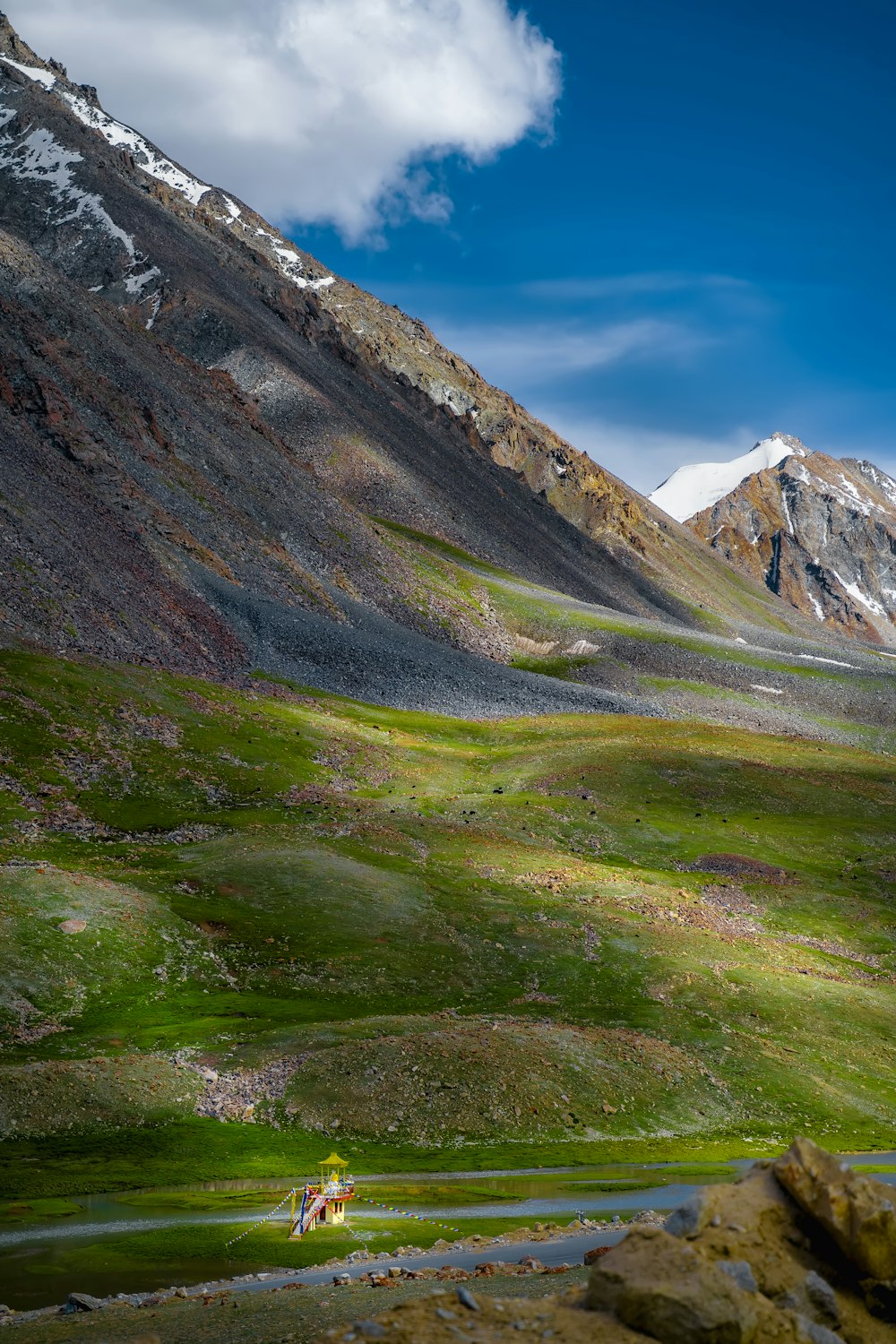 green grass field and mountains under blue sky during daytime