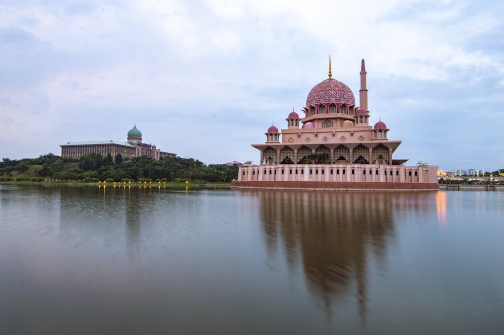 edificio in cemento marrone vicino allo specchio d'acqua durante il giorno