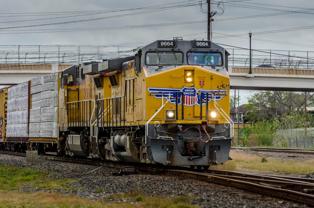 yellow and black train on rail tracks during daytime