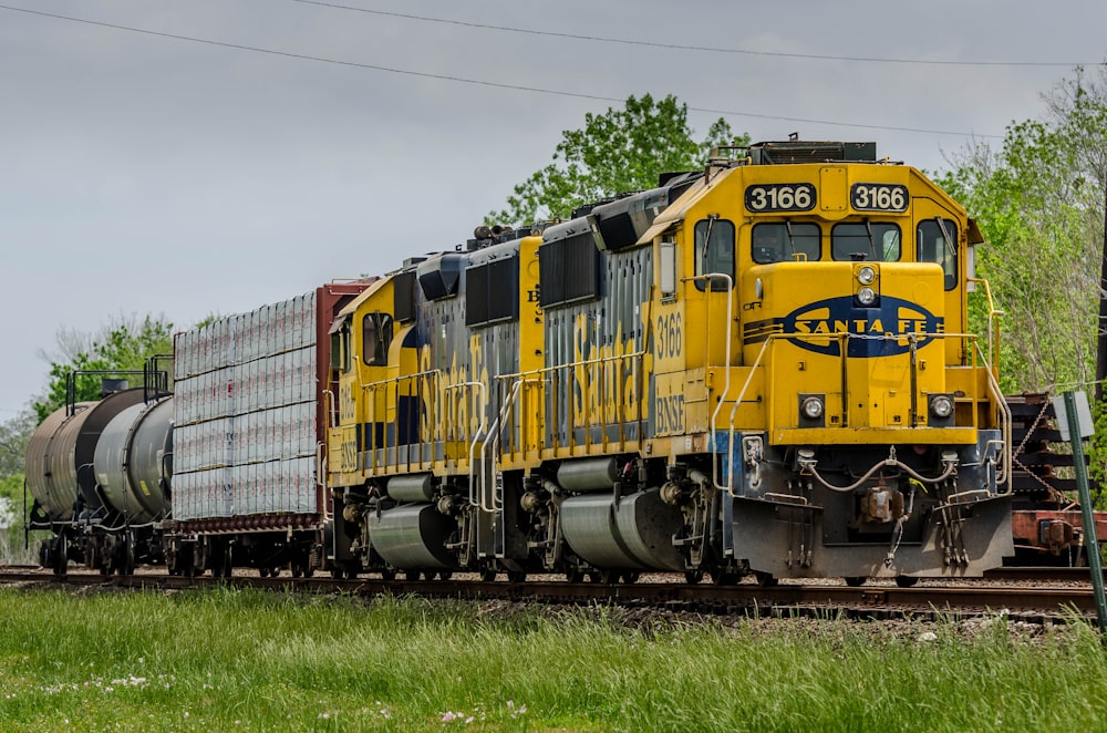 yellow and black train on rail tracks during daytime