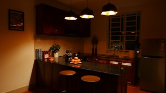 Brightly lit kitchen showing newly installed under-cabinet lighting with orange and dark blue decor.