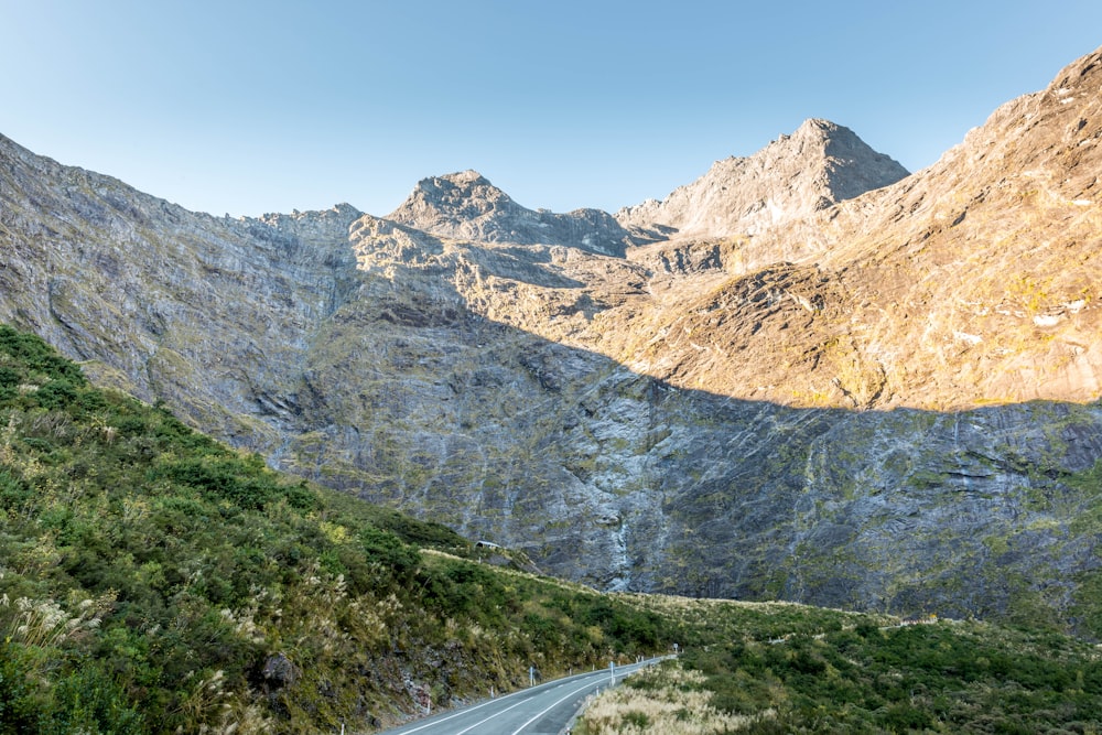 gray concrete road near mountain during daytime