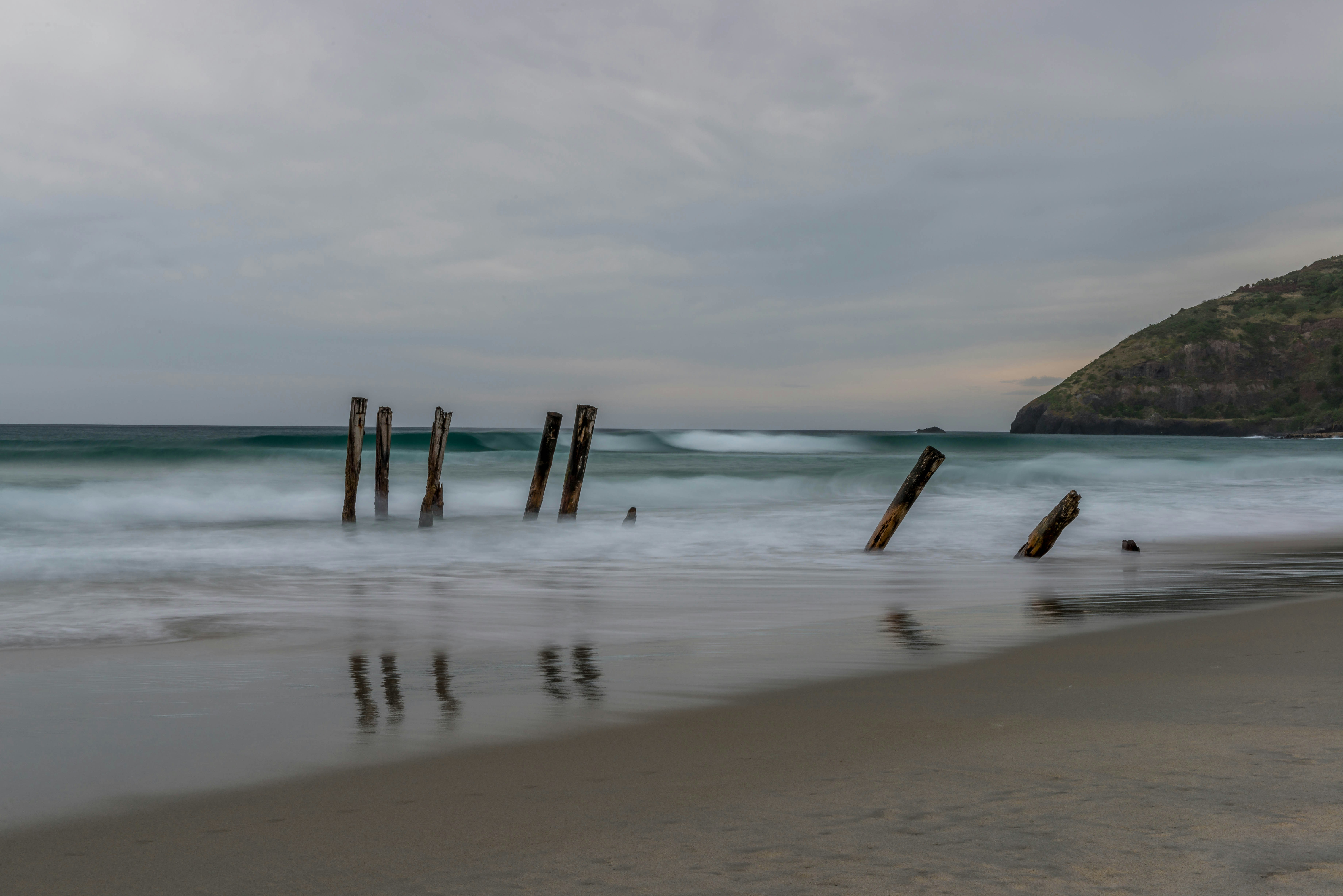 brown wooden fence on beach during daytime