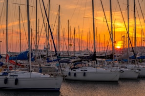 A panoramic view of Didim harbor filled with colorful sailboats at sunset