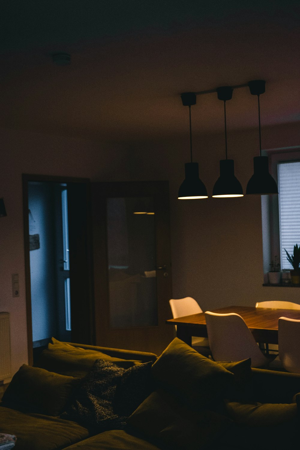 black pendant lamp turned on near brown wooden door