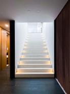 white staircase with brown wooden door