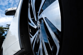 A close-up shot of shiny wheels and polished paint reflecting a clear sky.
