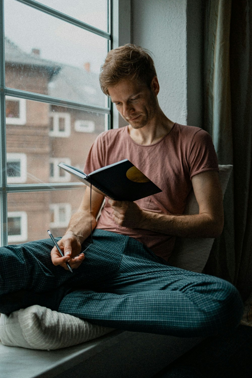 man in blue tank top holding book