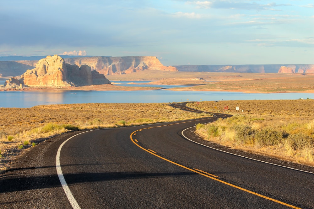 gray concrete road near brown mountain during daytime