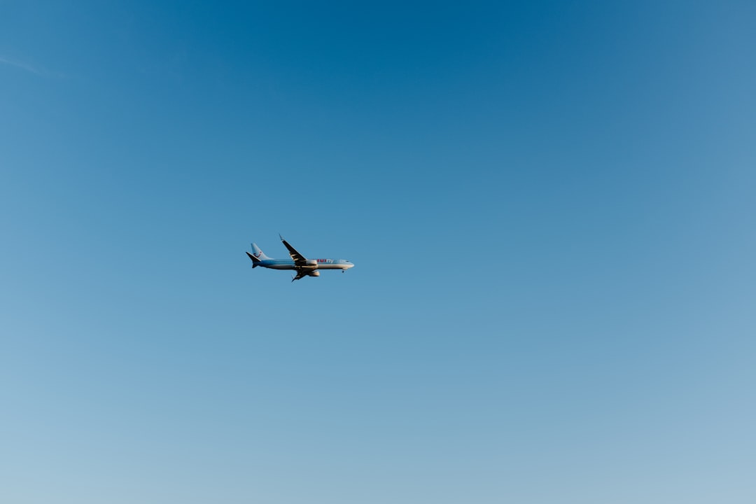white and black airplane in mid air during daytime