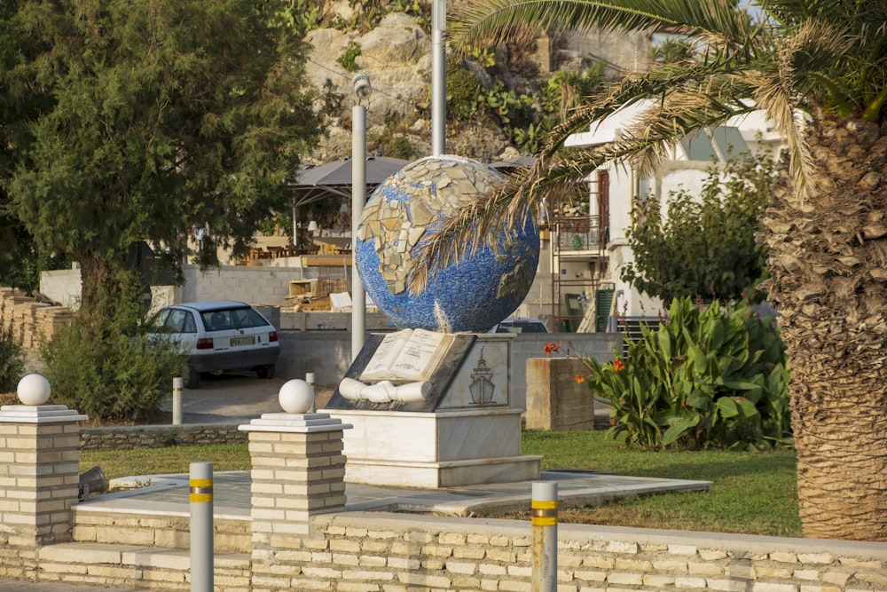 blue and white globe statue near white concrete building during daytime