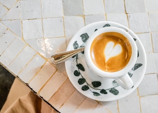 white and black ceramic cup with saucer