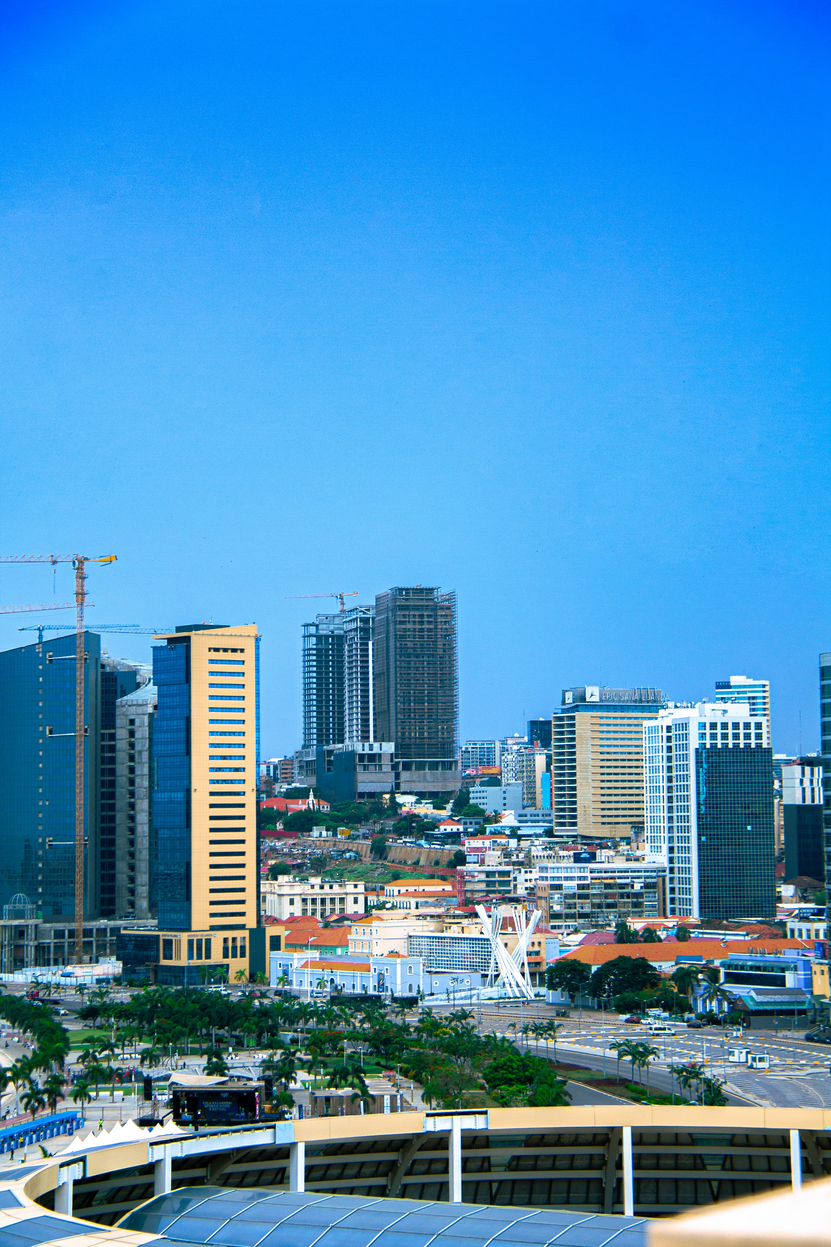 A vibrant cityscape of Somalia with new buildings and construction cranes under a clear sky.