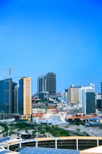 A vibrant city skyline showing ongoing construction sites with cranes and modern buildings.