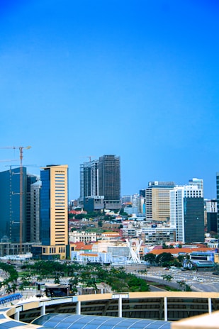A vibrant city skyline showing ongoing construction sites with cranes and modern buildings.