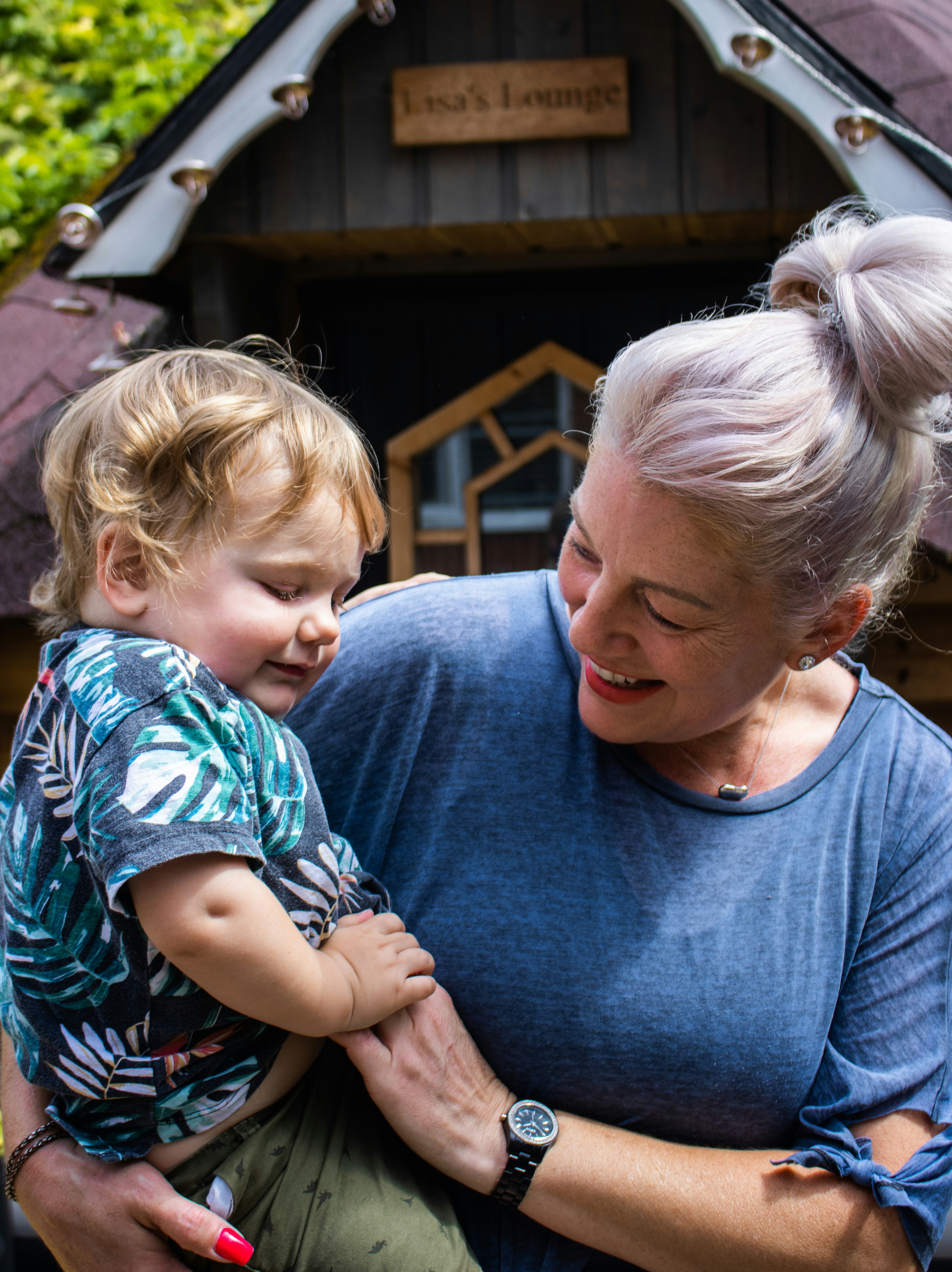 man in blue crew neck shirt carrying girl in blue and white floral shirt
