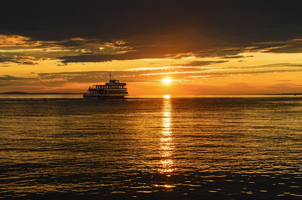 silhouette of ship on sea during sunset