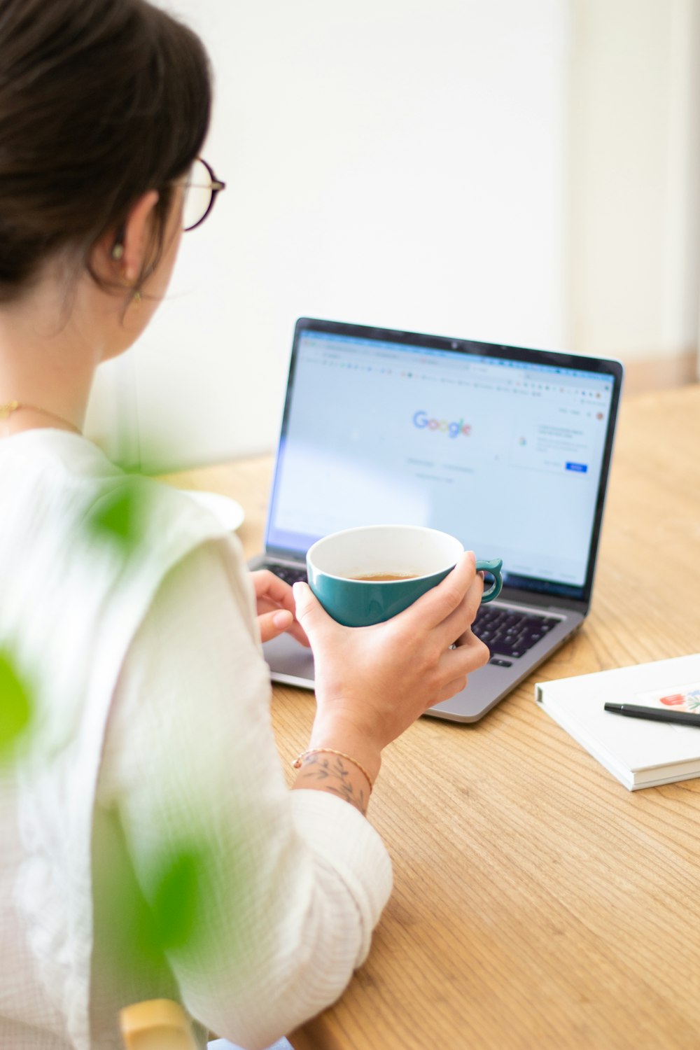 woman in white long sleeve shirt holding blue ceramic mug