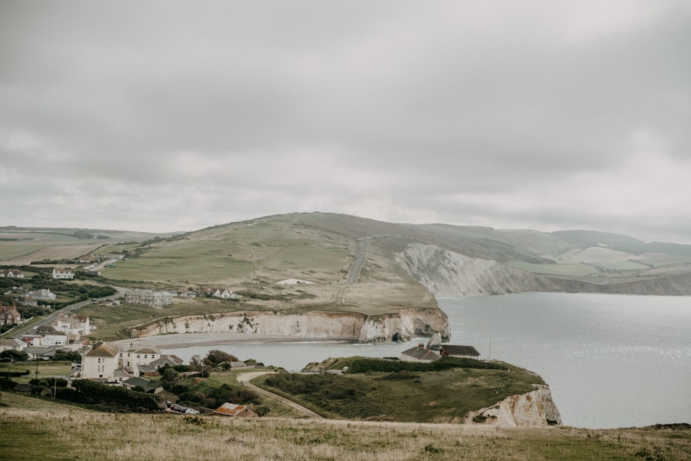 white and gray houses near body of water under white sky during daytime