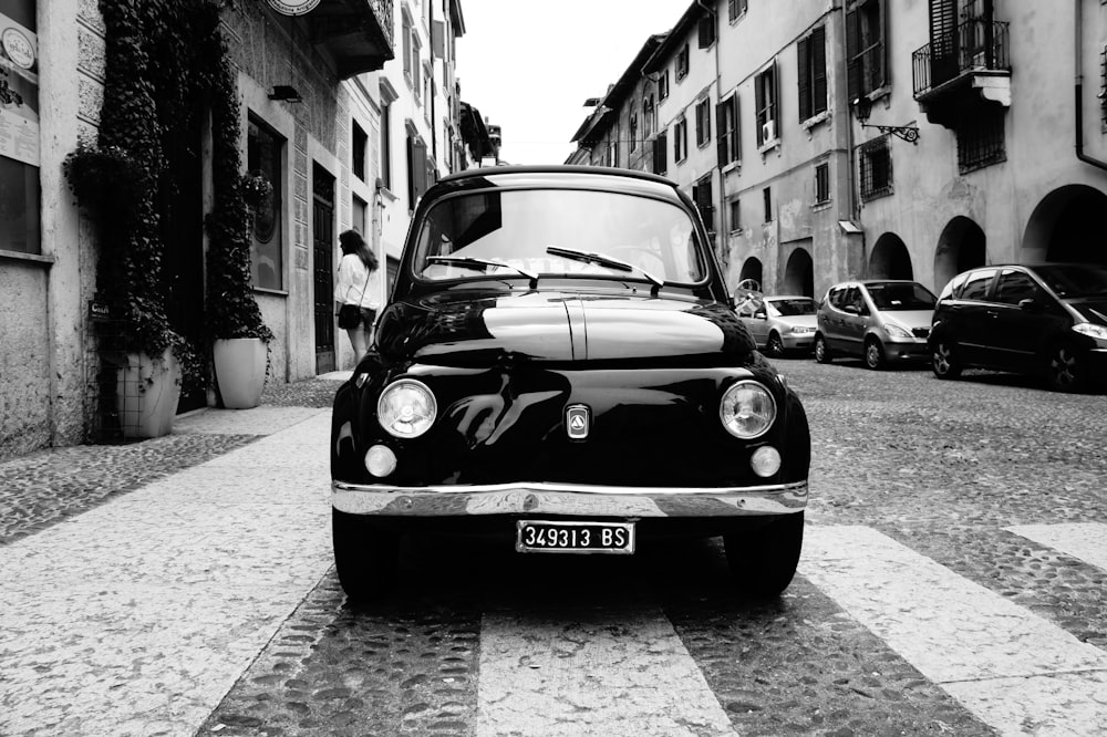 grayscale photo of classic car on street