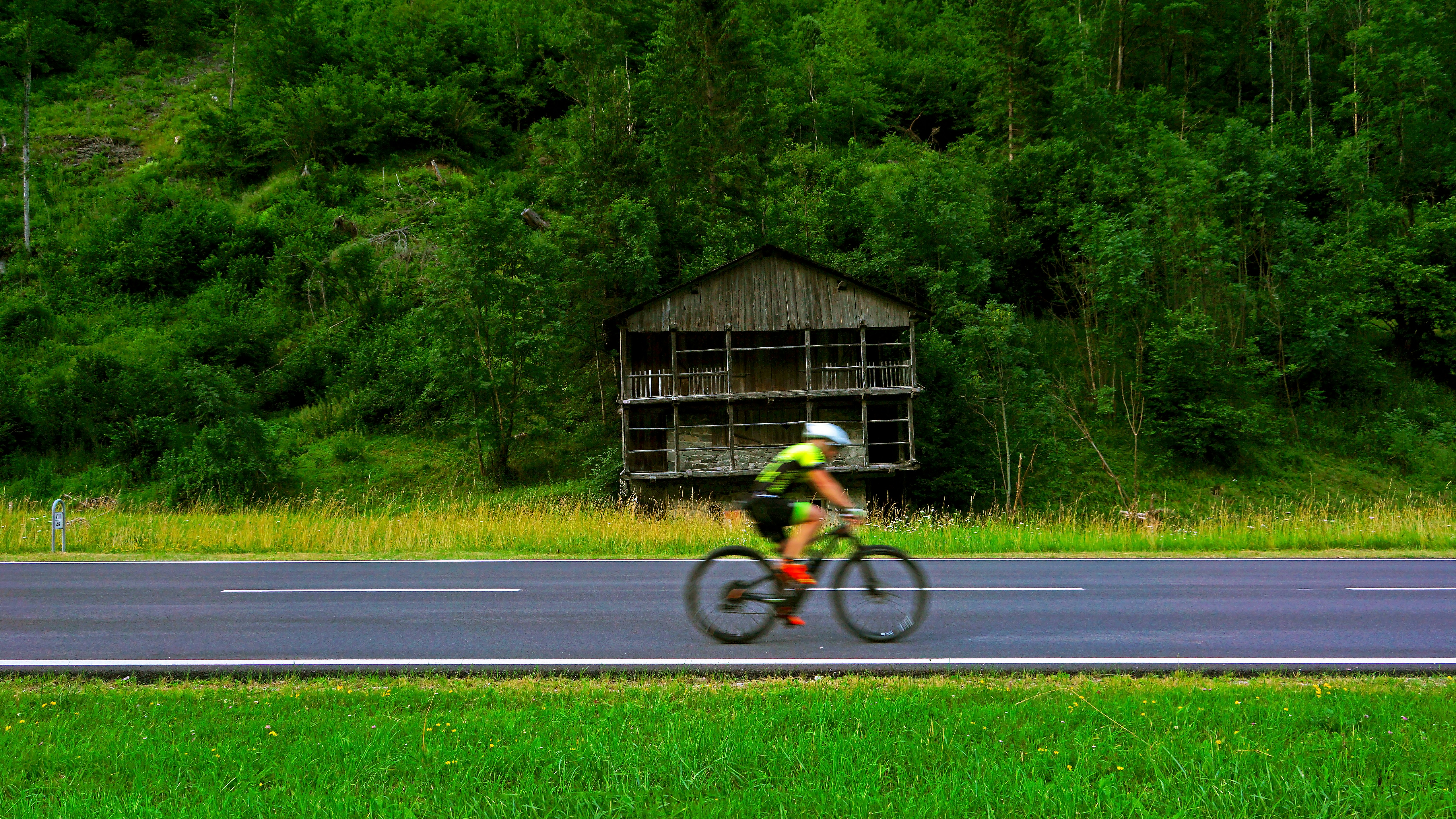 man in yellow shirt riding bicycle on road during daytime