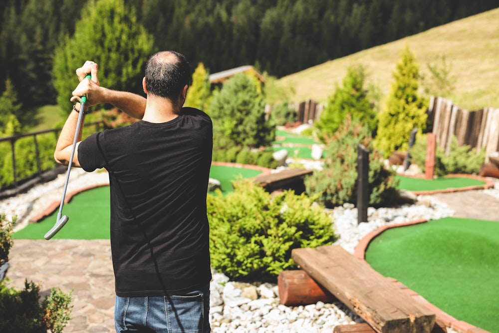 man in black t-shirt standing near swimming pool during daytime