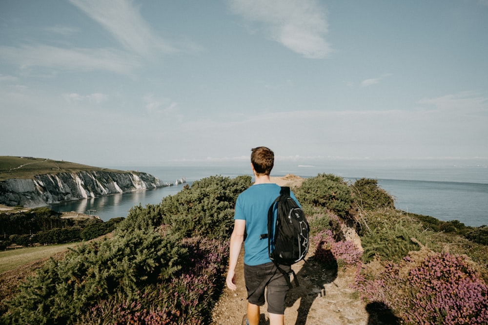 a man with a backpack walking up a hill