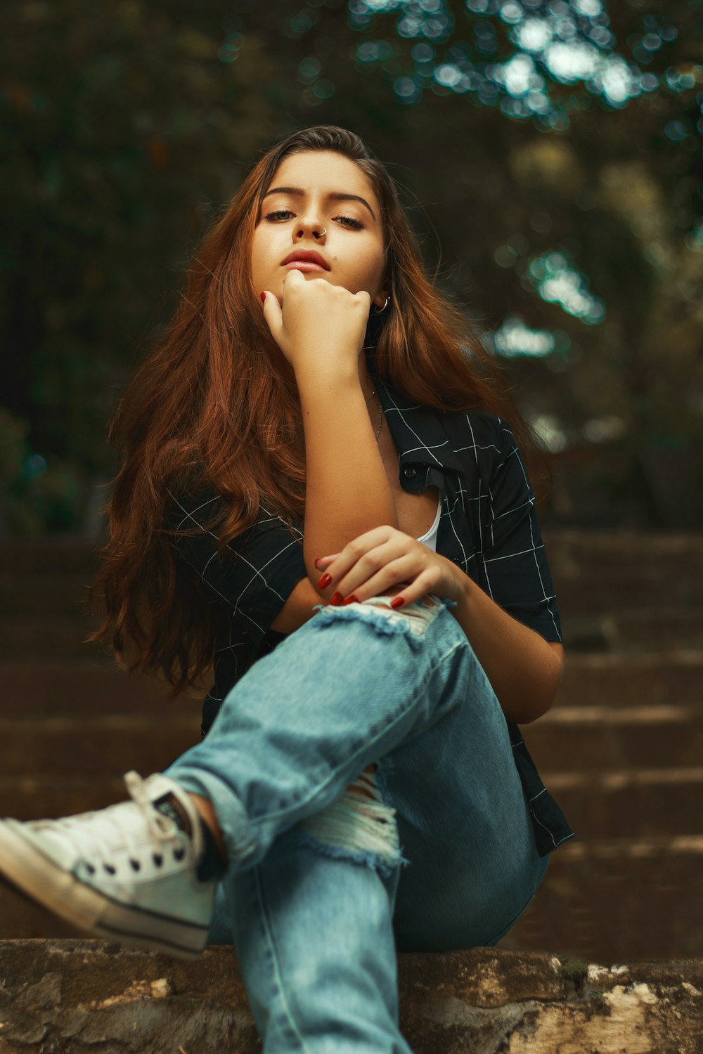 woman in blue denim jacket and blue denim jeans sitting on brown wooden bench