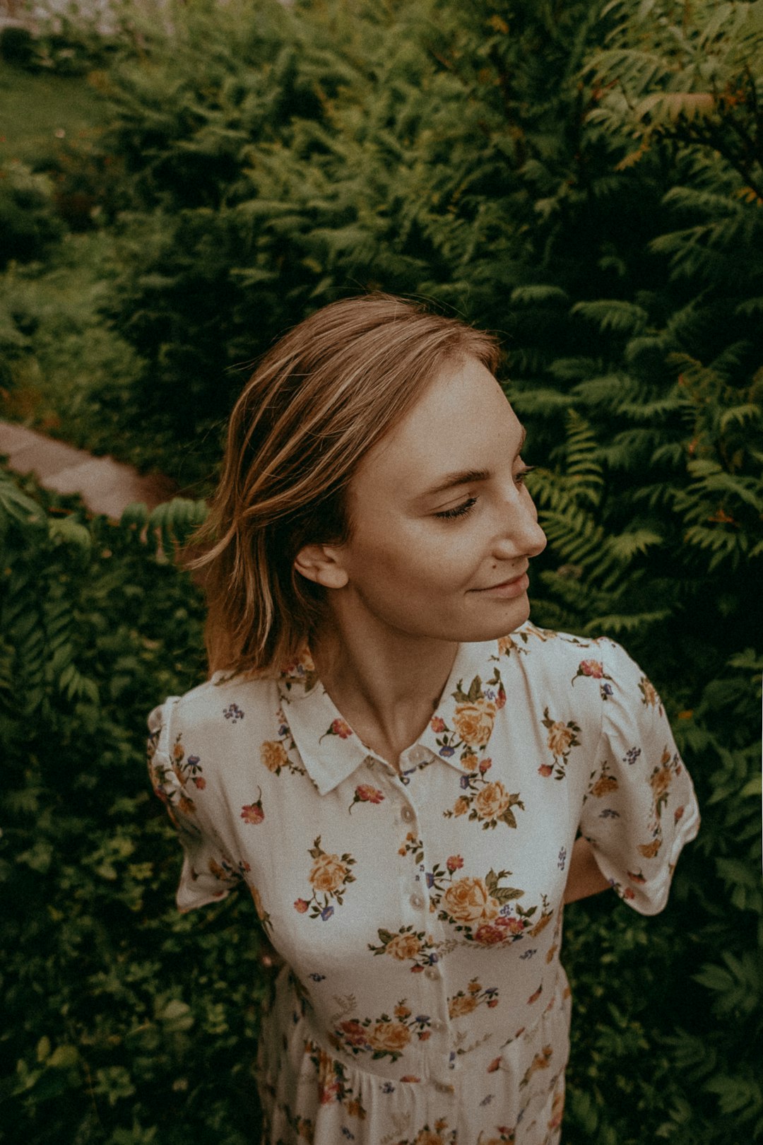 woman in white and brown floral button up shirt smiling