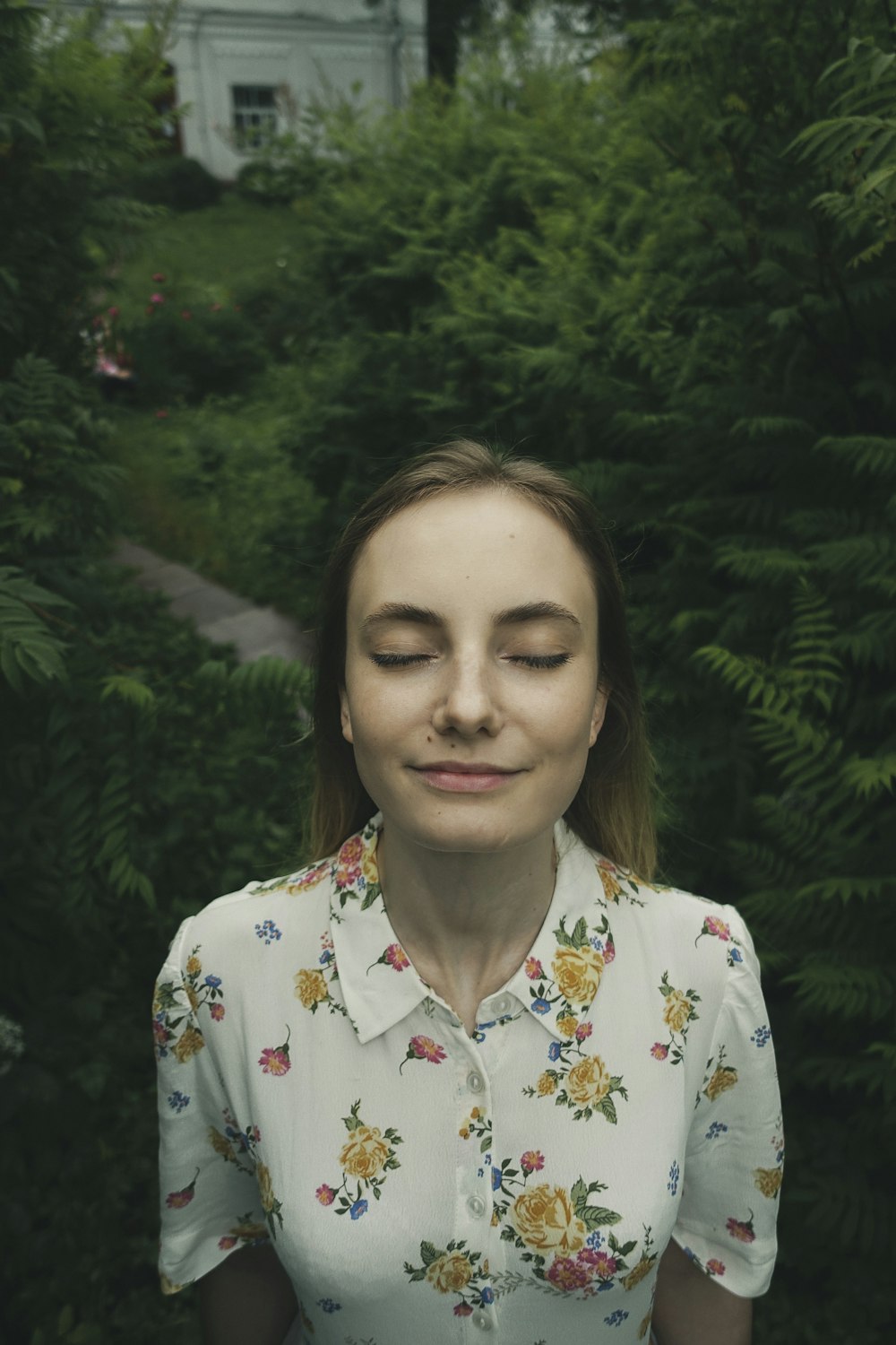 woman in white red and green floral button up shirt smiling