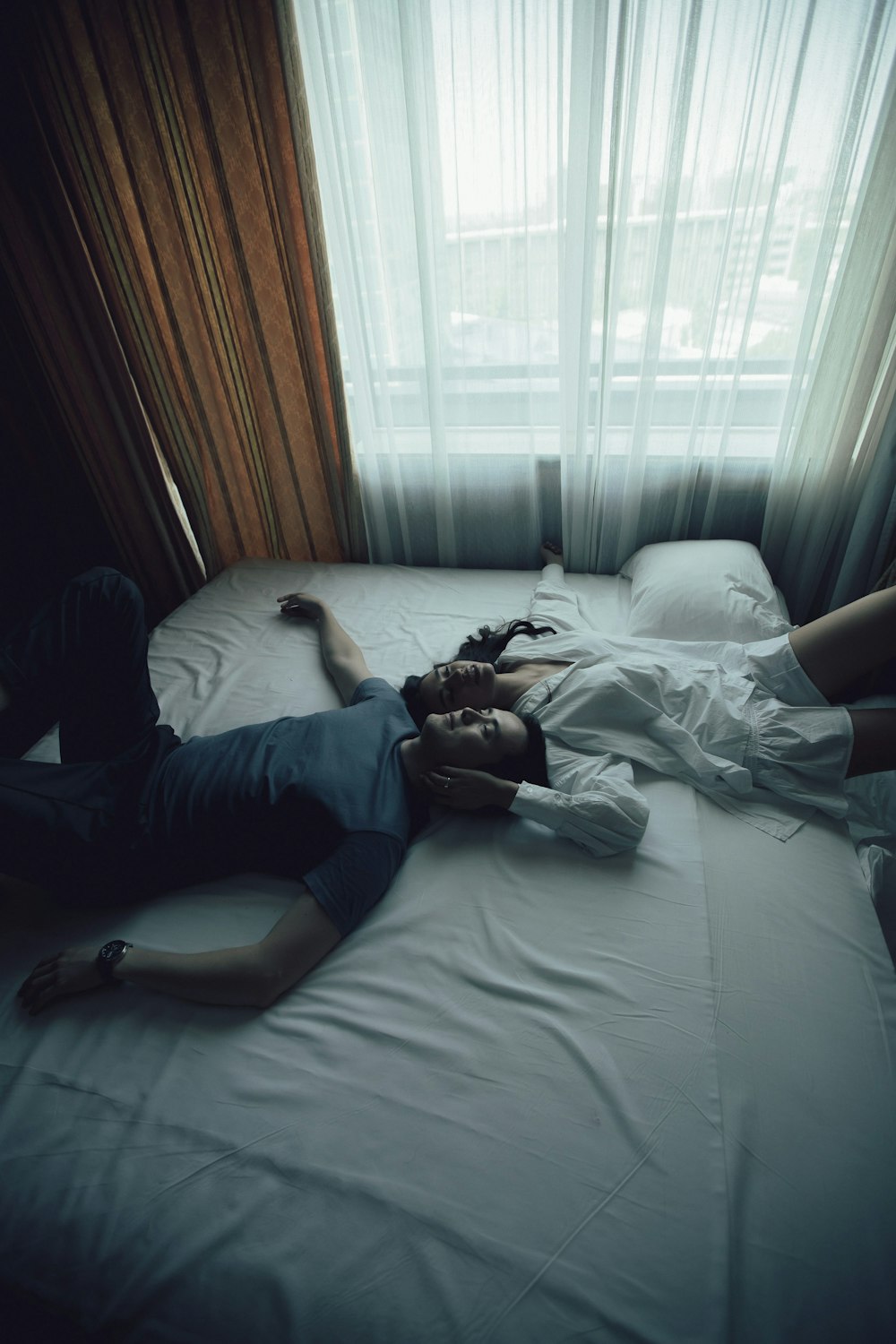 man in blue shirt lying on bed