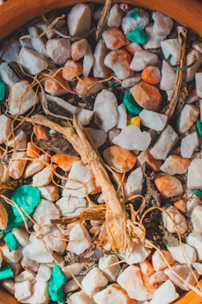 Arrangement of colorful Mexican natural stones beside macramé bracelets and dried earthy plants
