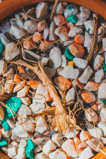 Arrangement of colorful Mexican natural stones beside macramé bracelets and dried earthy plants