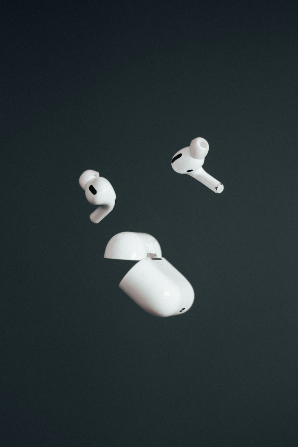a pair of white ear buds floating in the air