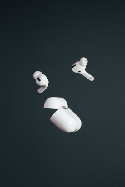 a pair of white ear buds floating in the air