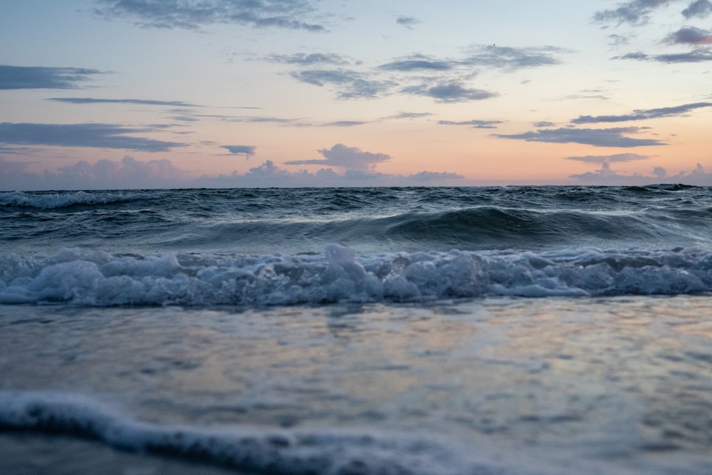 Meereswellen stürzen während des Sonnenuntergangs an Land