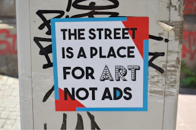 a sign on a pole that says the street is a place for art not ads