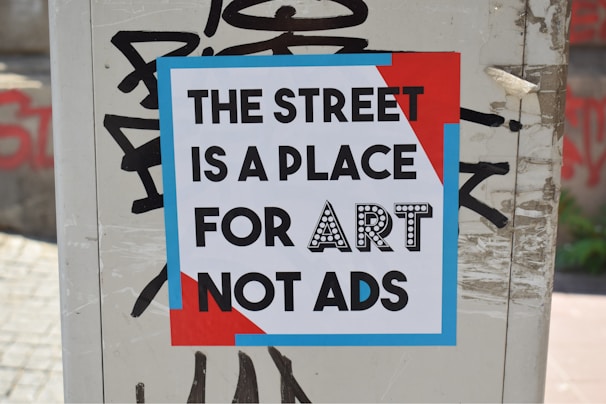 a sign on a pole that says the street is a place for art not ads