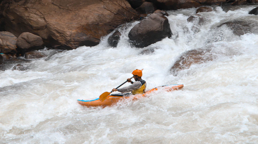 Kayaker paddling through splashing river water with gear exposed to spray