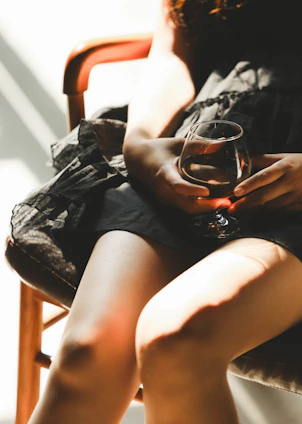 a woman sitting in a chair holding a wine glass
