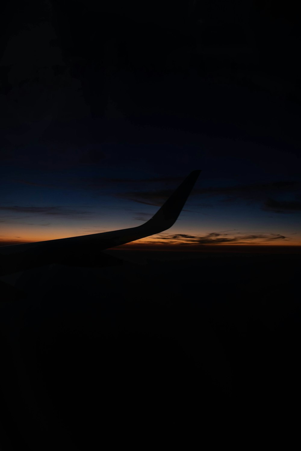 Ala de avión sobre las nubes durante la puesta del sol