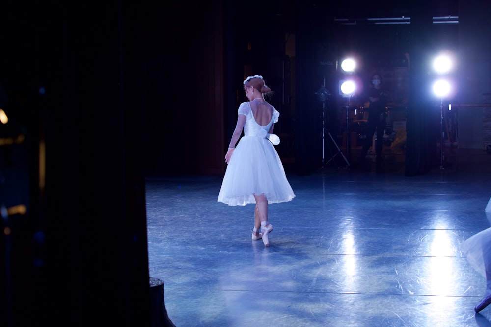 woman in white dress standing on blue floor