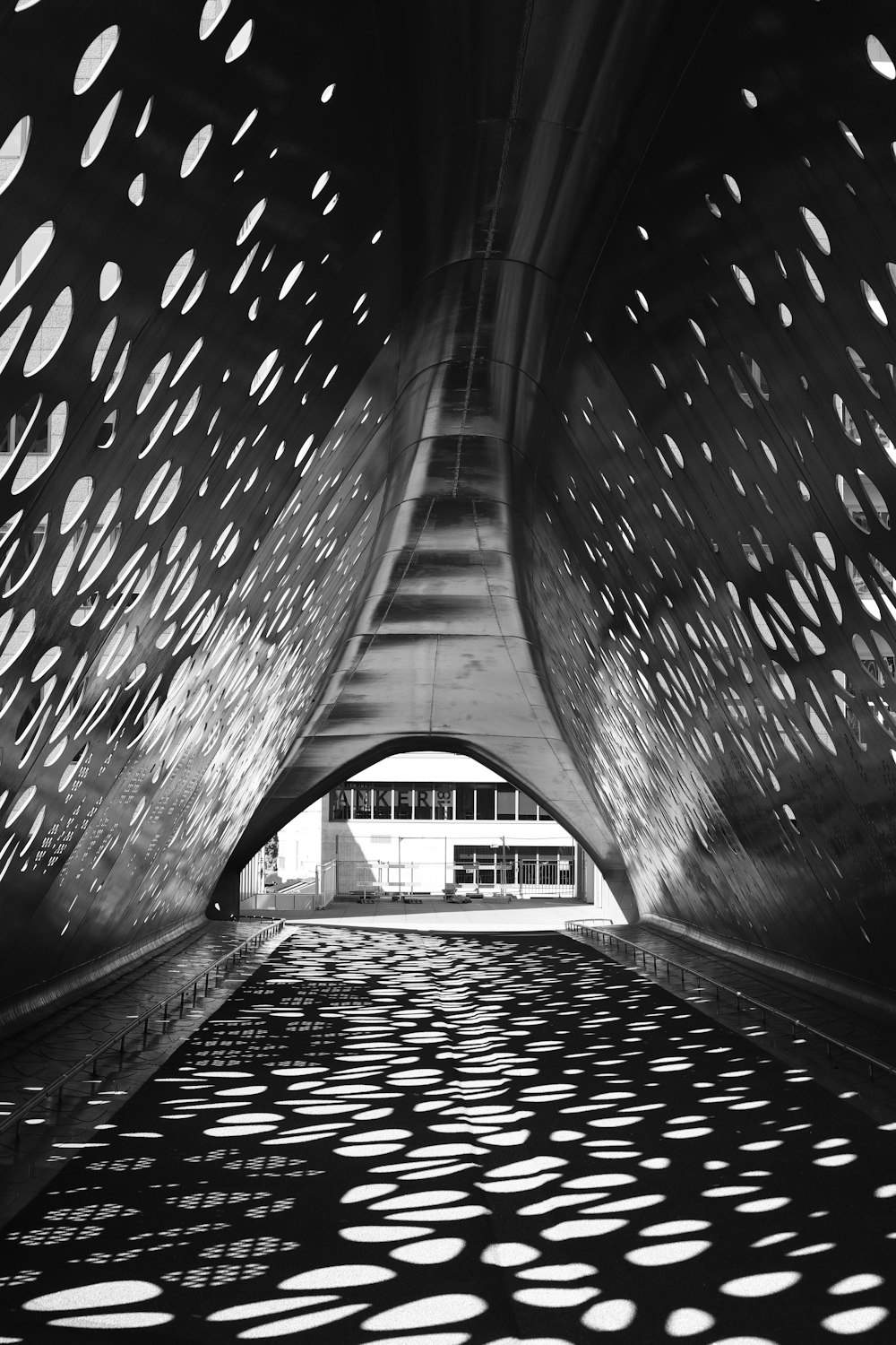 grayscale photo of tunnel with lights