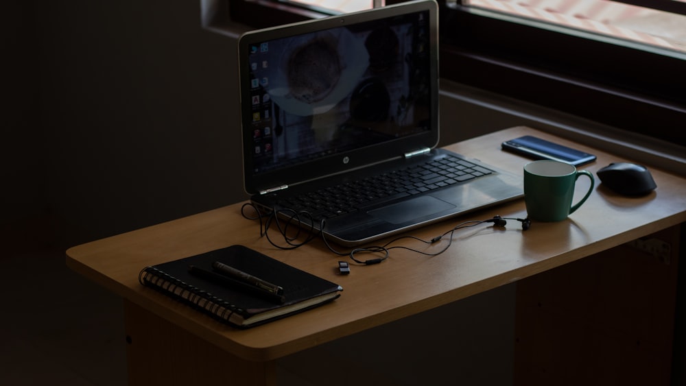 black laptop computer on brown wooden table