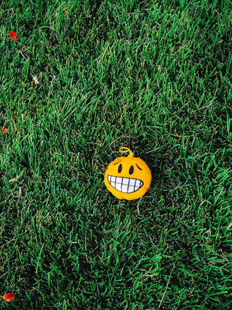 A bright yellow emoji with a cheeky grin and a question mark floating above, animated to move playfully.