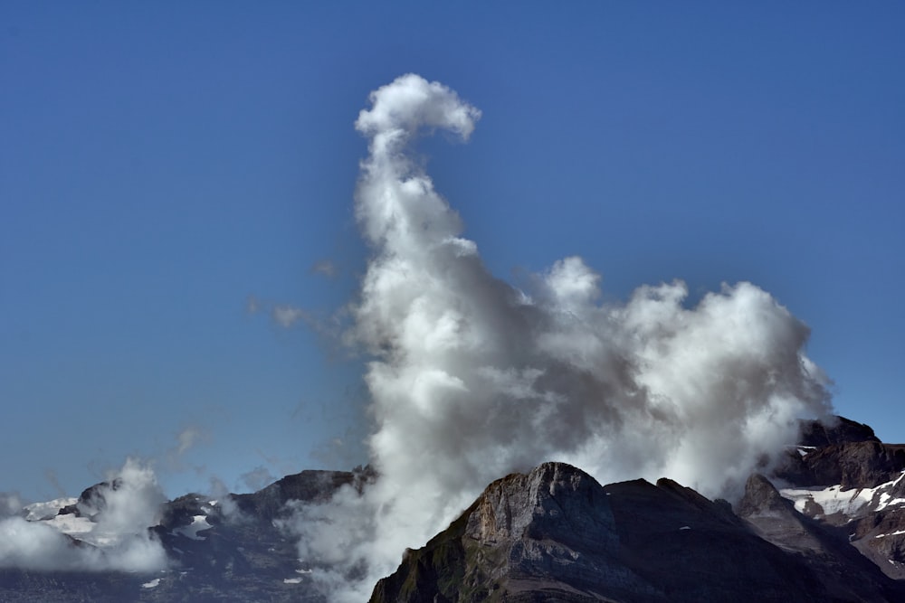 white clouds on top of brown mountain