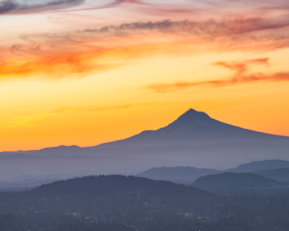 mountain range under orange and blue sky