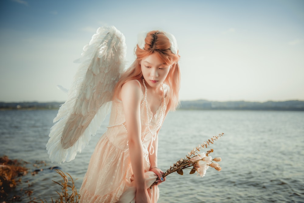 woman in pink dress holding white feather