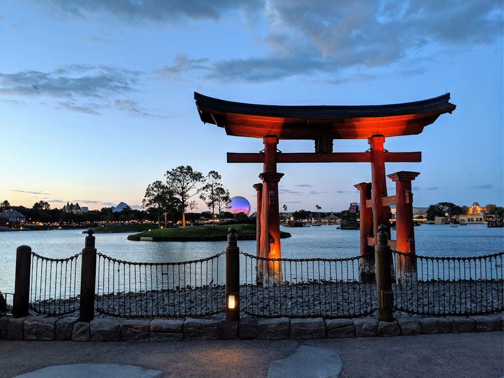 brown wooden gazebo near body of water during daytime